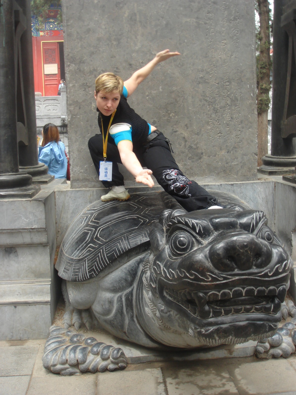 Liubov toont een Wushu positie op een stenen leeuw