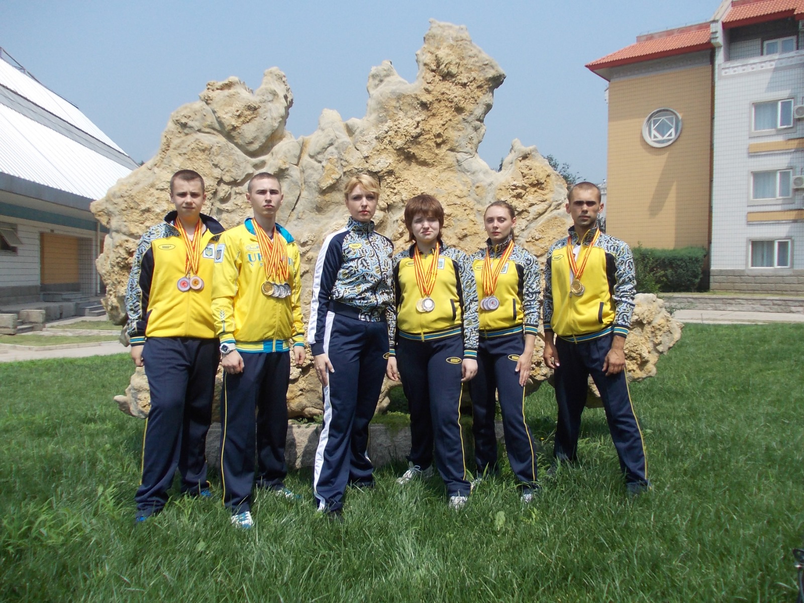 Het Oekraïense Wushu team groepsfoto met alle behaalde medailles samen met haar dochter