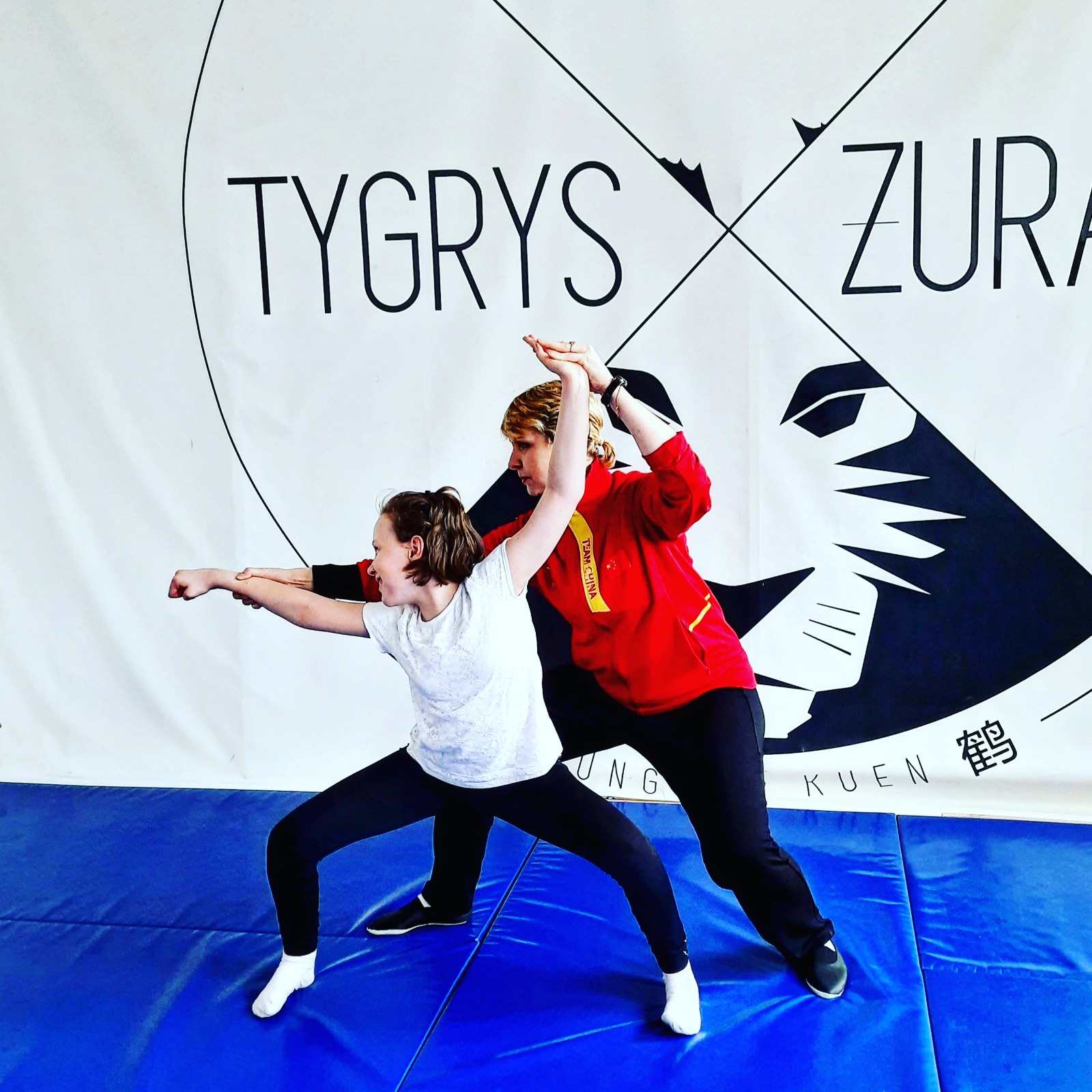 Liubov die een van haar studenten helpt om de goede positie te vinden tijdens een Wushu training