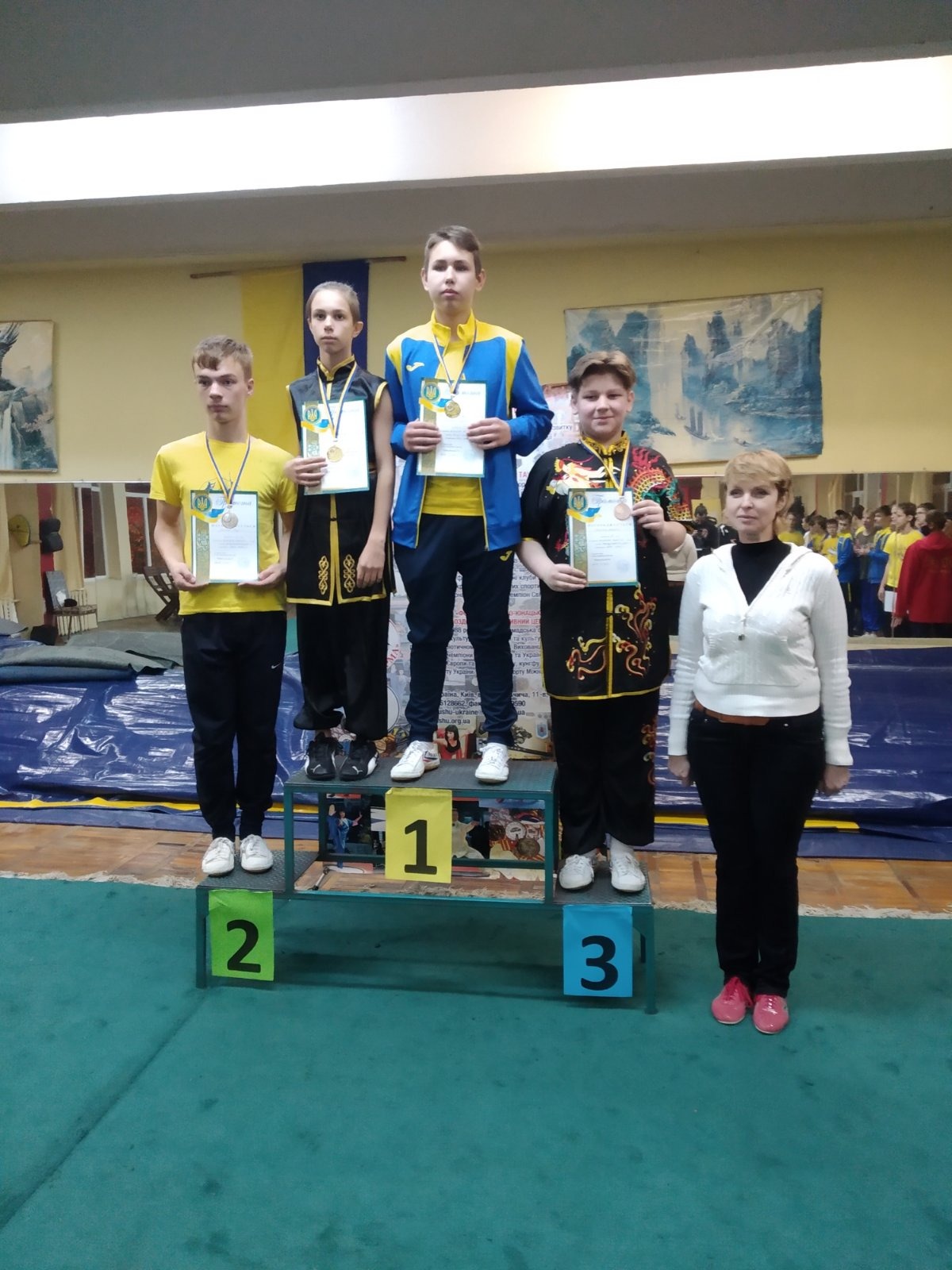 Liubov en haar studenten bij een Wushu wedstrijd met medailles en certificaten
